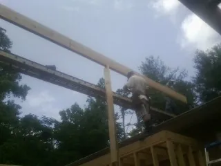 Carpenter setting a ridge beam over a new addition frame — Ice Dam Removal by Roofing Brothers in Ville Platte
