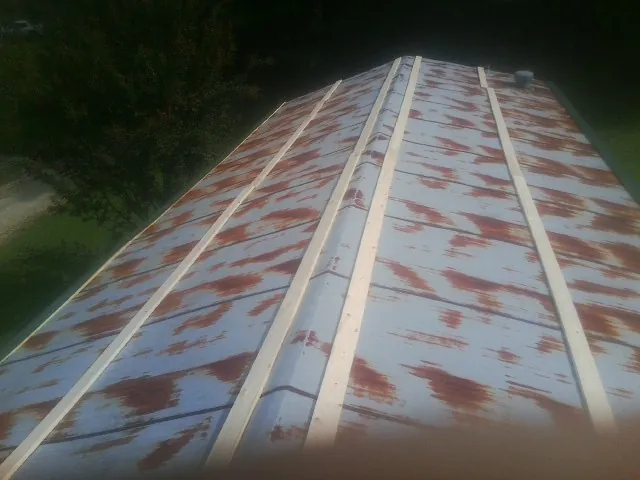 Rusted metal roof panels with new wood purlins before replacement — Storm Damage Roof Repair in Ville Platte by Roofing Brothers