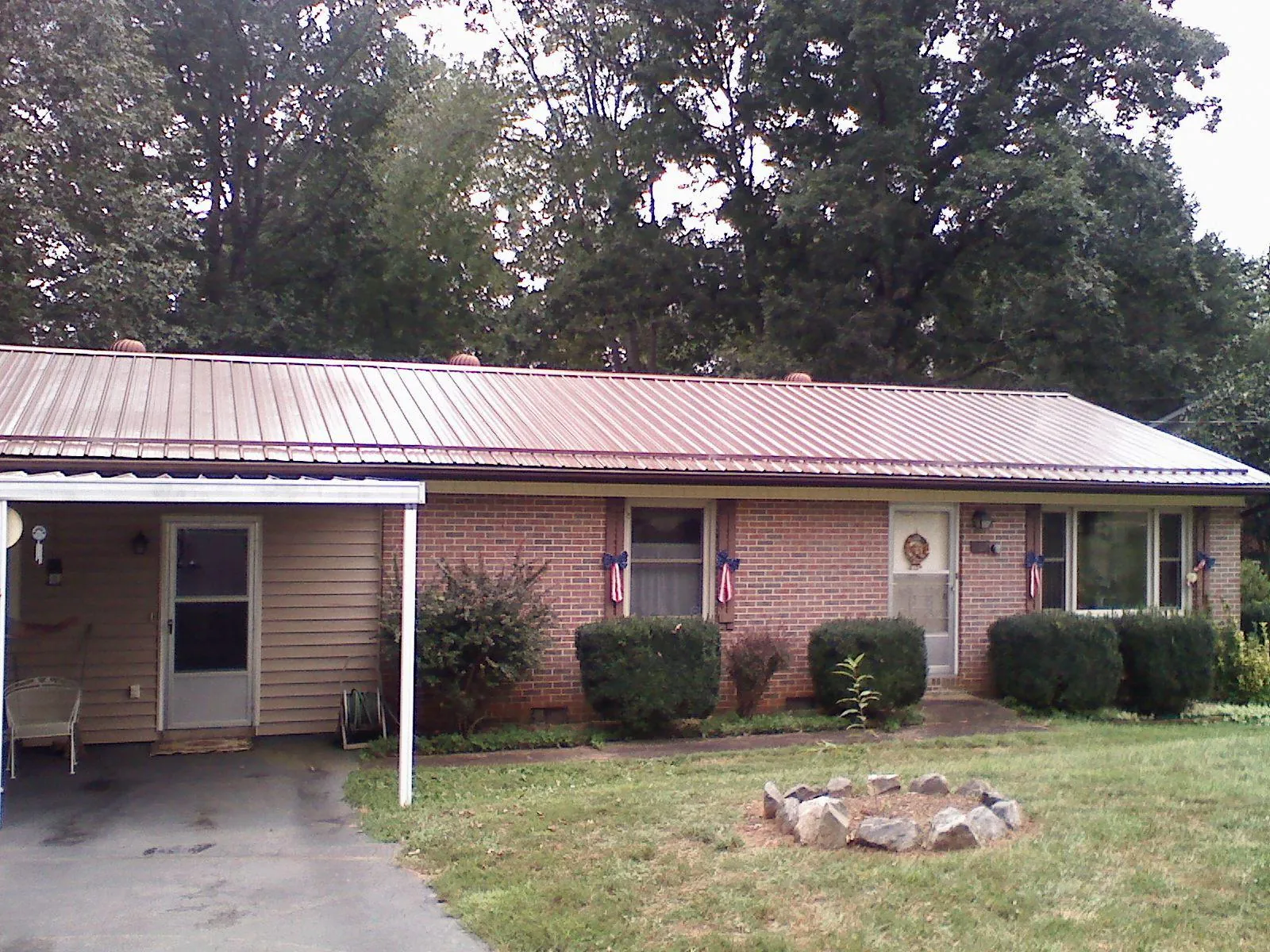 Bronze metal roof and carport on a brick ranch home — Roof Repair work by our crew in Ville Platte