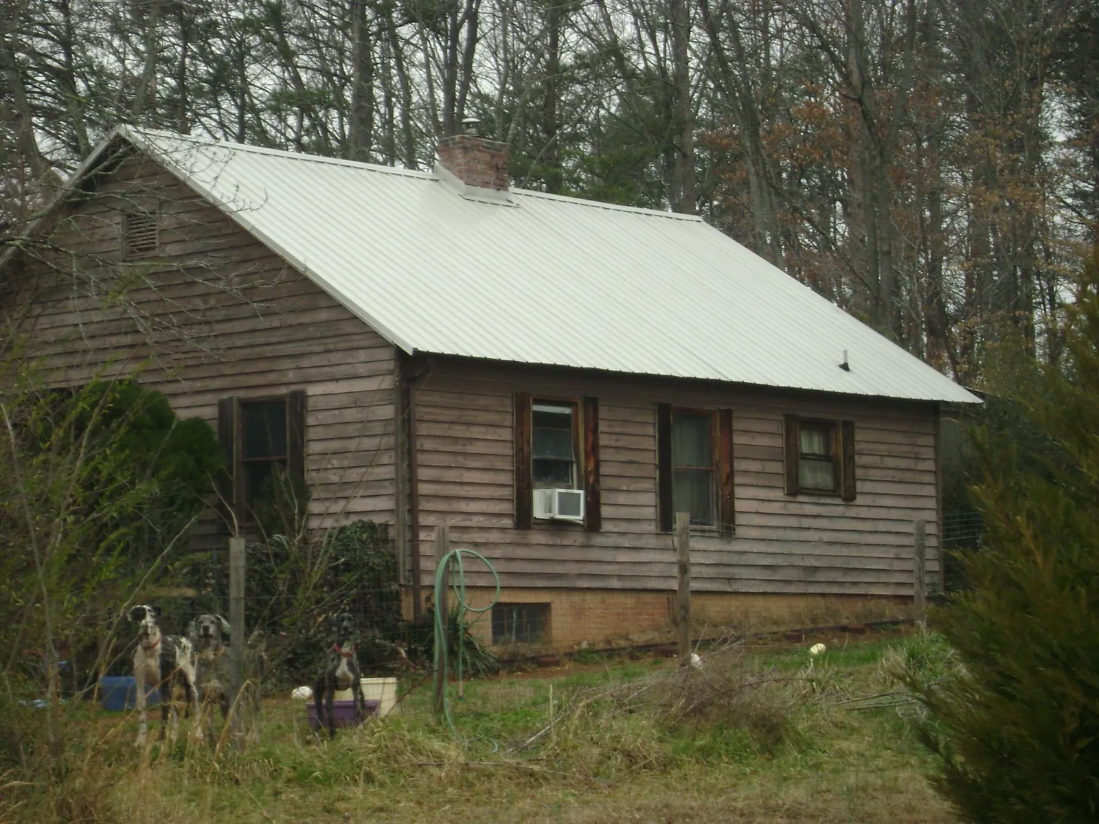 White metal roof on an old wood sided farmhouse, from a Metal Roof Installation job in Ville Platte